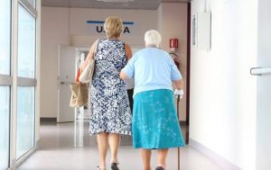 elderly woman being escorted through hospital